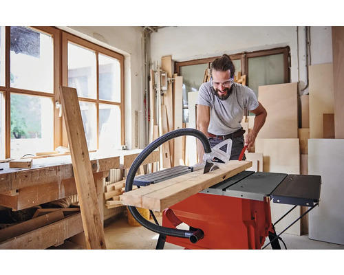 Bărbat tăind lemn cu un ferăstrău circular de masă într-un atelier
