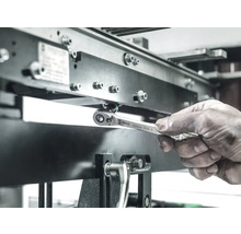 Un muncitor folosește o cheie tubulară Wera Zyklop 8004 A pentru a strânge un șurub pe o structură metalică.