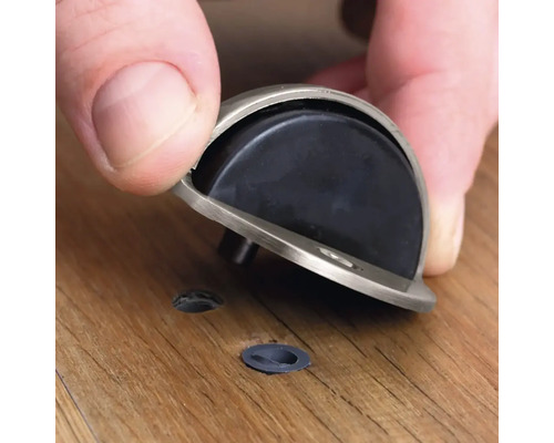 Montarea unui opritor de ușă pe o podea de lemn.