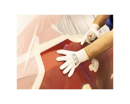 O persoană poartă mănuși de protecție în timp ce lucrează la o mașină.