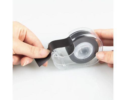 O rolă de bandă izolatoare într-un distribuitor transparent este ținută de două mâini.