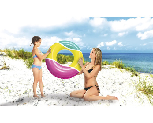 Mamă și fiică țin un colac de înot pe plajă