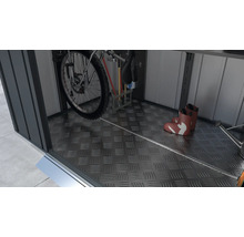 Interiorul unui șopron de scule cu o bicicletă, unelte de grădinărit și cizme de cauciuc pe o podea din tablă striată