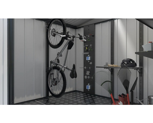 Bicicletă pe suportul de perete într-o magazie de scule împreună cu unelte și unelte de grădină