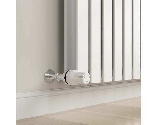 Prim-plan al unui radiator alb cu termostat pe un perete