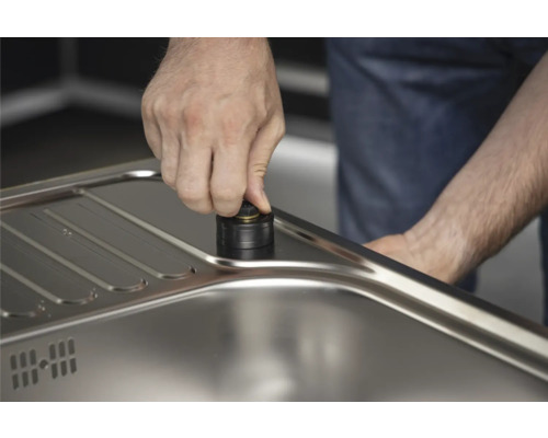 Prim-plan cu sistem de scurgere manual din metal într-o chiuvetă