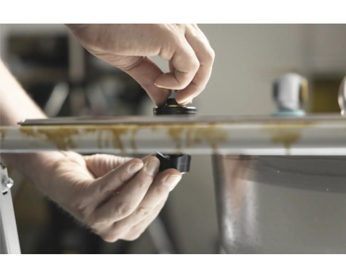 Mâini care instalează o componentă pe o chiuvetă