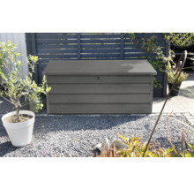 Scenă de grădină cu o cutie de depozitare gri pentru exterior.