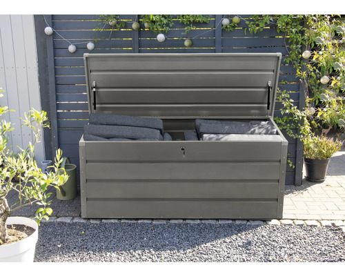 Ladă de grădină gri deschisă cu perne în grădină