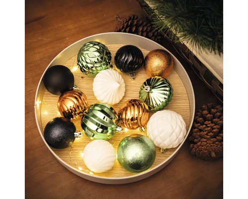 Aranjament decorativ de globuri de pom înr-un castron cu un șir de lumini
