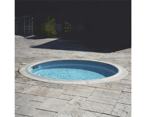 Piscină rotundă cu gresie într-o grădină