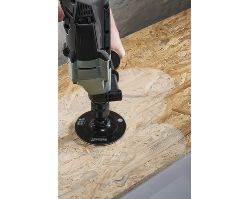 O mașină de șlefuit prelucrează o placă de lemn.