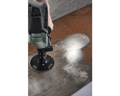 O persoană șlefuiește o suprafață metalică cu o mașină de șlefuit.