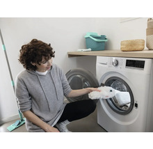 Femeie care pune un capac de mop într-o mașină de spălat