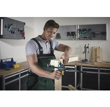 Bărbat care fixează bucăți de lemn cu o clemă de mână într-un atelier