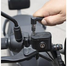 O persoană folosește o șurubelniță cu atașament unghiular pentru a lucra la o motocicletă.