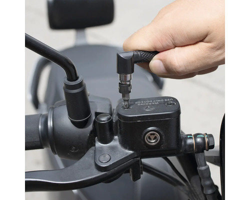 O persoană folosește o șurubelniță cu atașament unghiular pentru a lucra la o motocicletă.