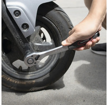 Cheie cu clichet strângând o anvelopă de motocicletă.