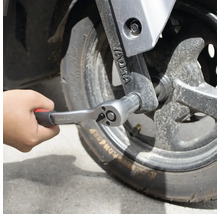 Mână fixând un clichet pe o roată.