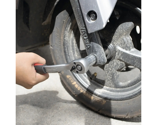 Mână fixând un clichet pe o roată.