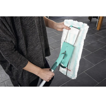 O persoană ține un mop cu o husă lavabilă. Mopul are un mâner telescopic și un cap rotativ pentru curățarea podelelor.
