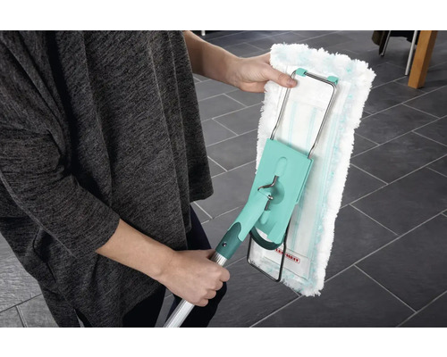 O persoană ține un mop cu o husă lavabilă. Mopul are un mâner telescopic și un cap rotativ pentru curățarea podelelor.