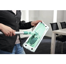 Femeie ținând în mână un mop cu husă din microfibră
