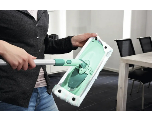 Femeie ținând în mână un mop cu husă din microfibră