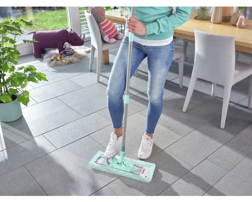 Femeie șterge podeaua cu gresie cu un mop