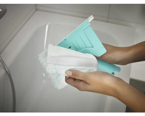 Ștergător cu husă lavabilă în mâini în fața căzii