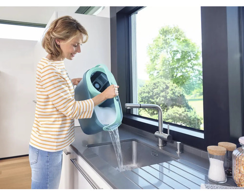 Femeie varsă găleată cu detergent într-o chiuvetă