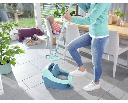 Femeie care folosește un mop și o găleată pentru a curăța podeaua