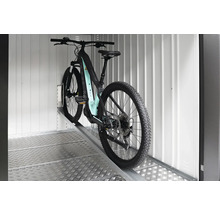 Bicicletă electrică de munte pe o rampă într-un spațiu de depozitare.