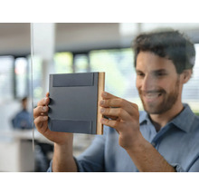 Bărbat atașează un indicator magnetic de ușă pe o ușă de sticlă în birou