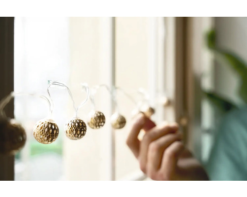 Ghirlandă luminoasă decorativă cu bile fixată pe fereastră