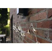 Ghirlandă luminoasă cu becuri fixată pe un zid de cărămidă