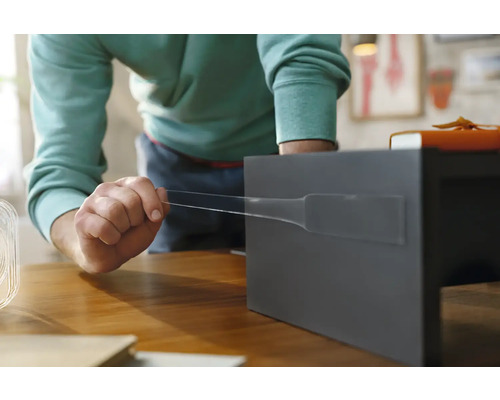 O persoană fixează o bandă adezivă pe un raft gri.