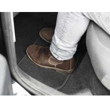 Spațiul pentru picioare al unei mașini cu covoraș și pantof de piele