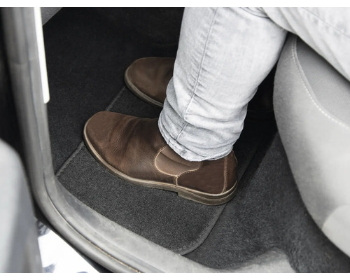 Spațiul pentru picioare al unei mașini cu covoraș și pantof de piele