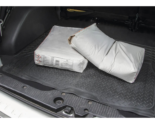 Doi saci de ciment în portbagajul unei mașini.