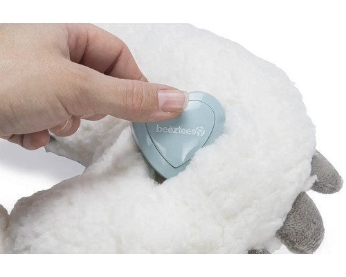 Mână care atinge sigla Beetztees pe o jucărie de pluș.