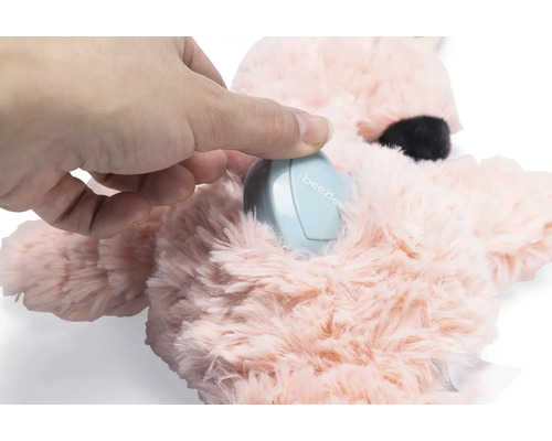 O mână pune un dispozitiv electronic într-o jucărie de pluș