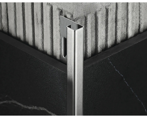 Prim-plan cu o șină metalică pentru plăci de faianță într-un colț între două plăci