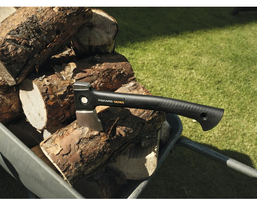 Topor Fiskars Ultra pe un stoc de lemne într-o roabă