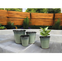 Patru vase de ceramică pentru plante de diferite dimensiuni în grădină.