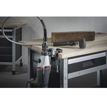 Mașină de găurit cu ax flexibil pe menghină pe un banc de lucru