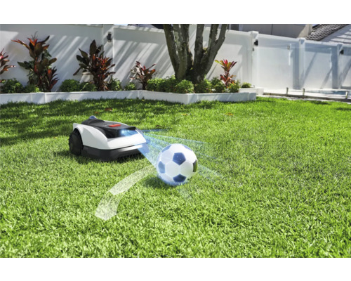 Robot de tuns iarba pe gazon cu minge de fotbal