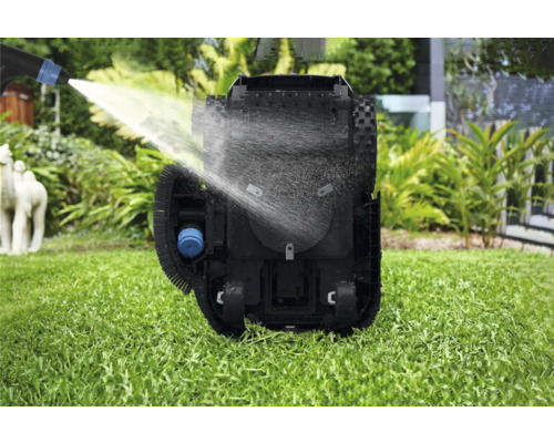 Curățarea unui robot de tuns iarba cu jet de apă pe un gazon