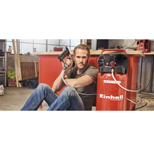 Bărbat șezând cu compresor Einhell și capsator în atelier