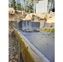 Imagine cu blocuri de beton așezate pe un strat izolator într-o groapă de construcție